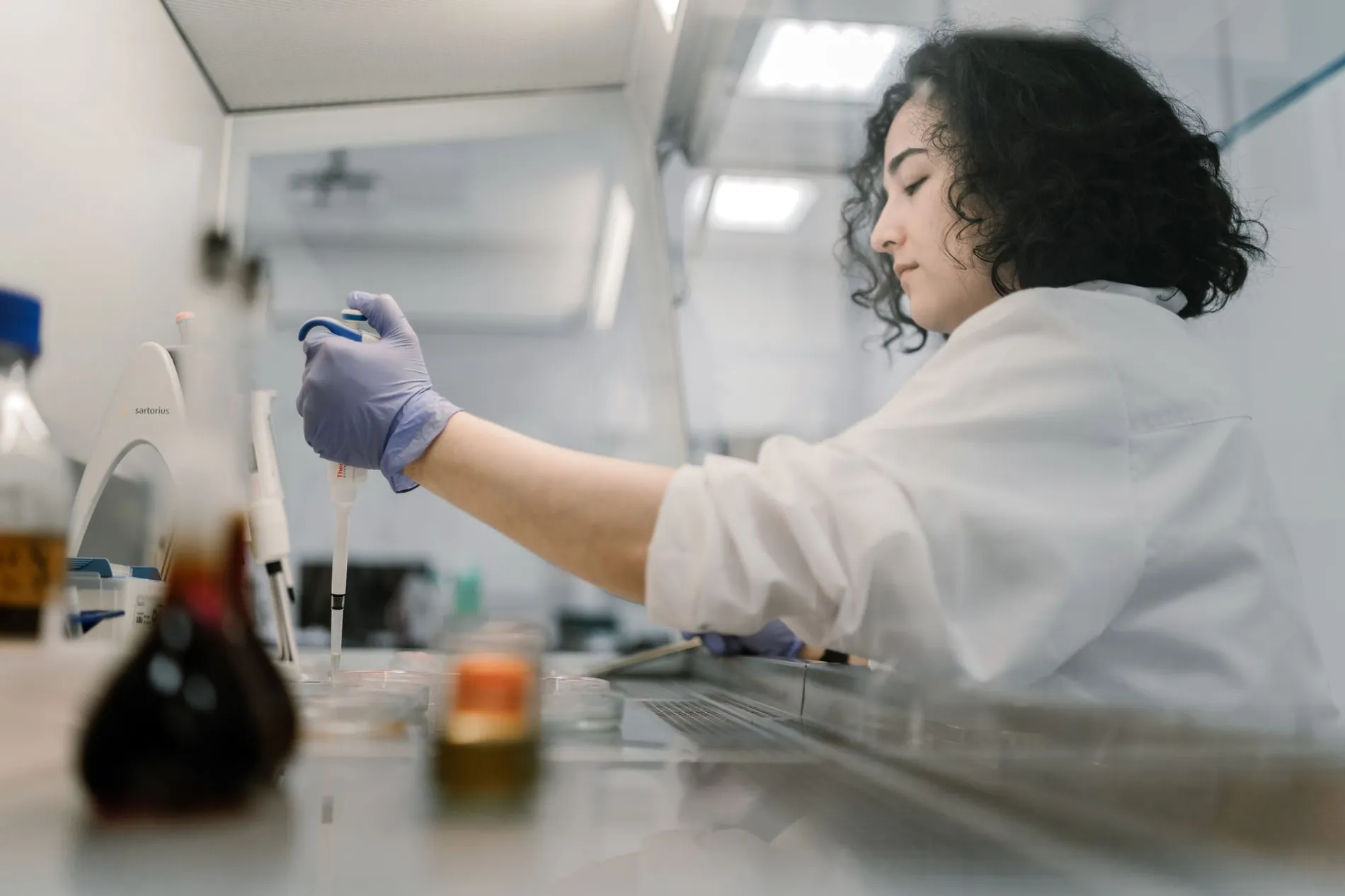 Researcher pipetting into a multi-well plate